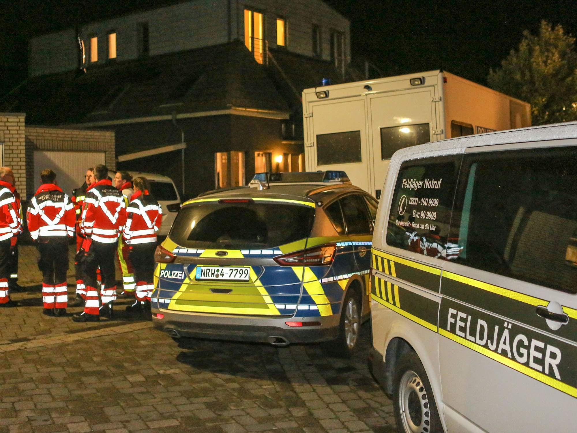 Zoll und Polizei stehen bei einer Razzia vor einem Gebäude.