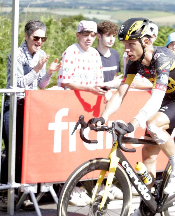 Tony Martin fährt auf seinem Rennrad, sein Arm und sein Bein sind verbunden.