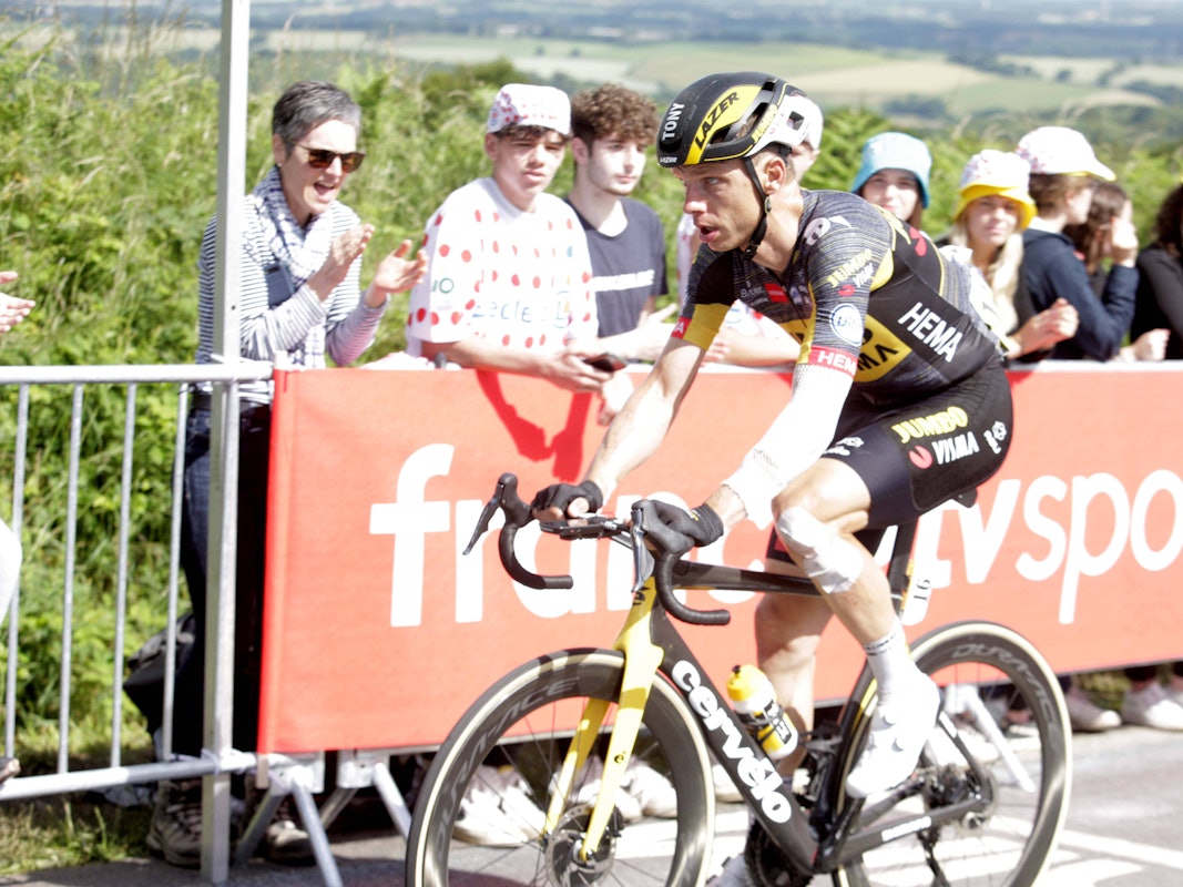 Tony Martin fährt auf seinem Rennrad, sein Arm und sein Bein sind verbunden.