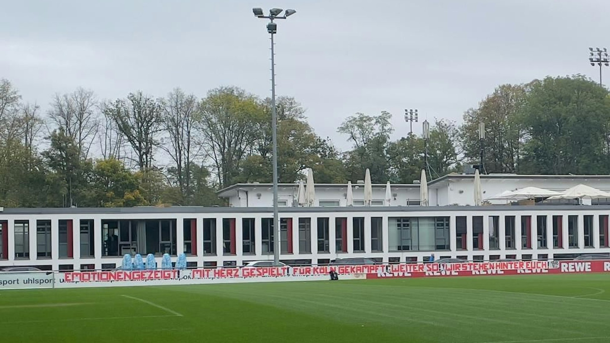 Beim Abschlusstraining des 1. FC Köln hängt ein Banner der Ultras.