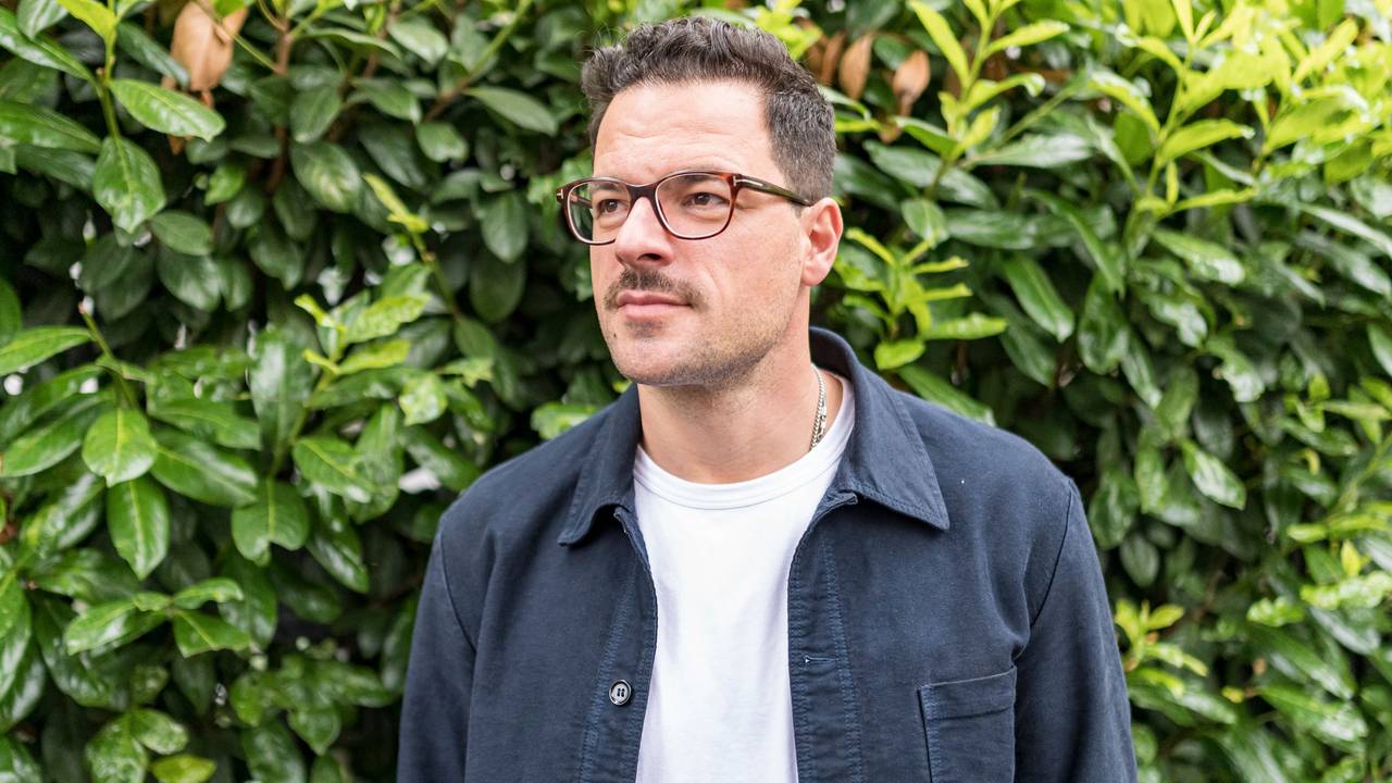 Tobias Licht steht vor einer Hecke in Köln Sülz.