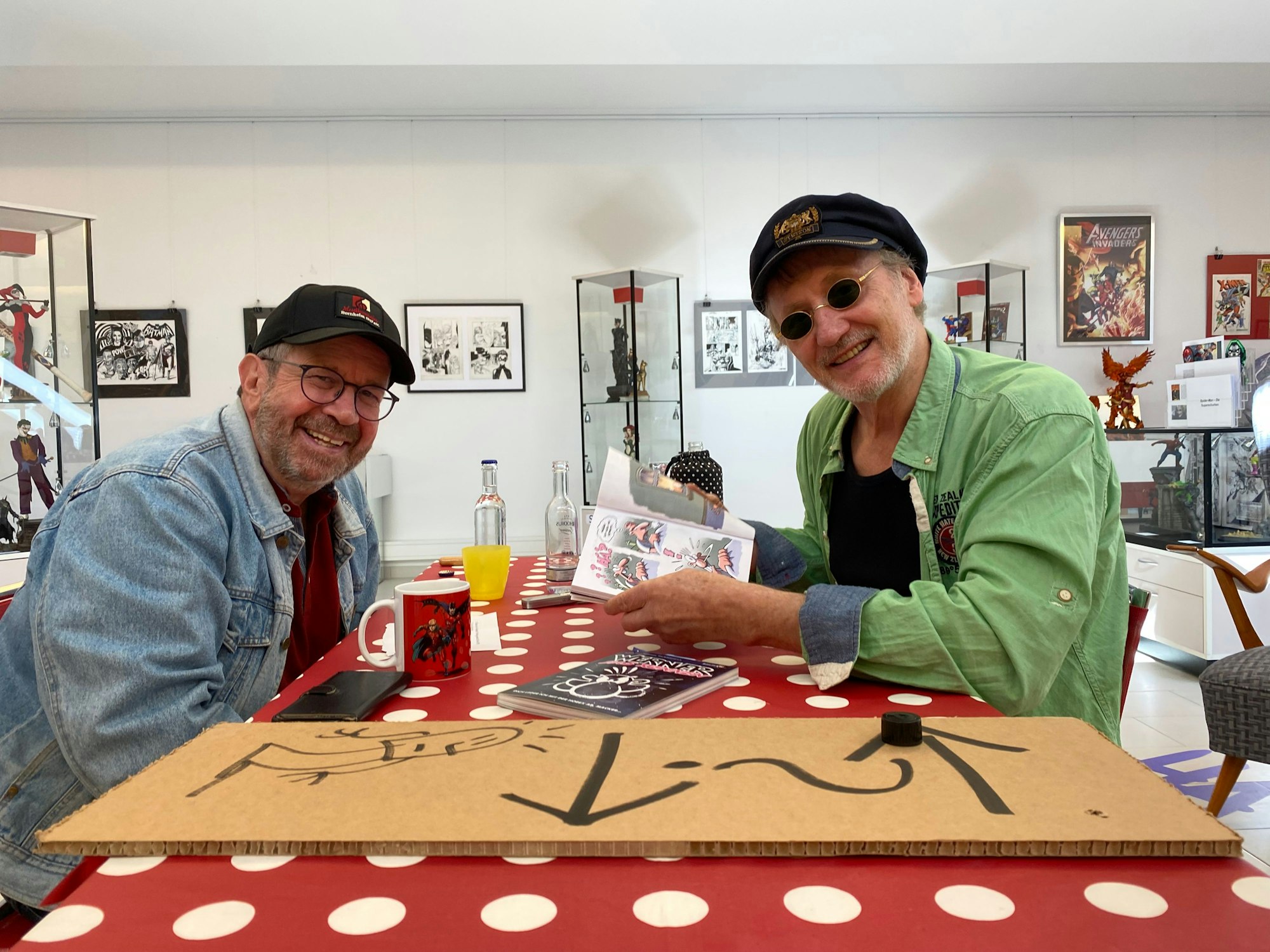 Comiczeichner Brösel und EXPRESS-Reporter Christof Ernst sitzen sich gegenüber.