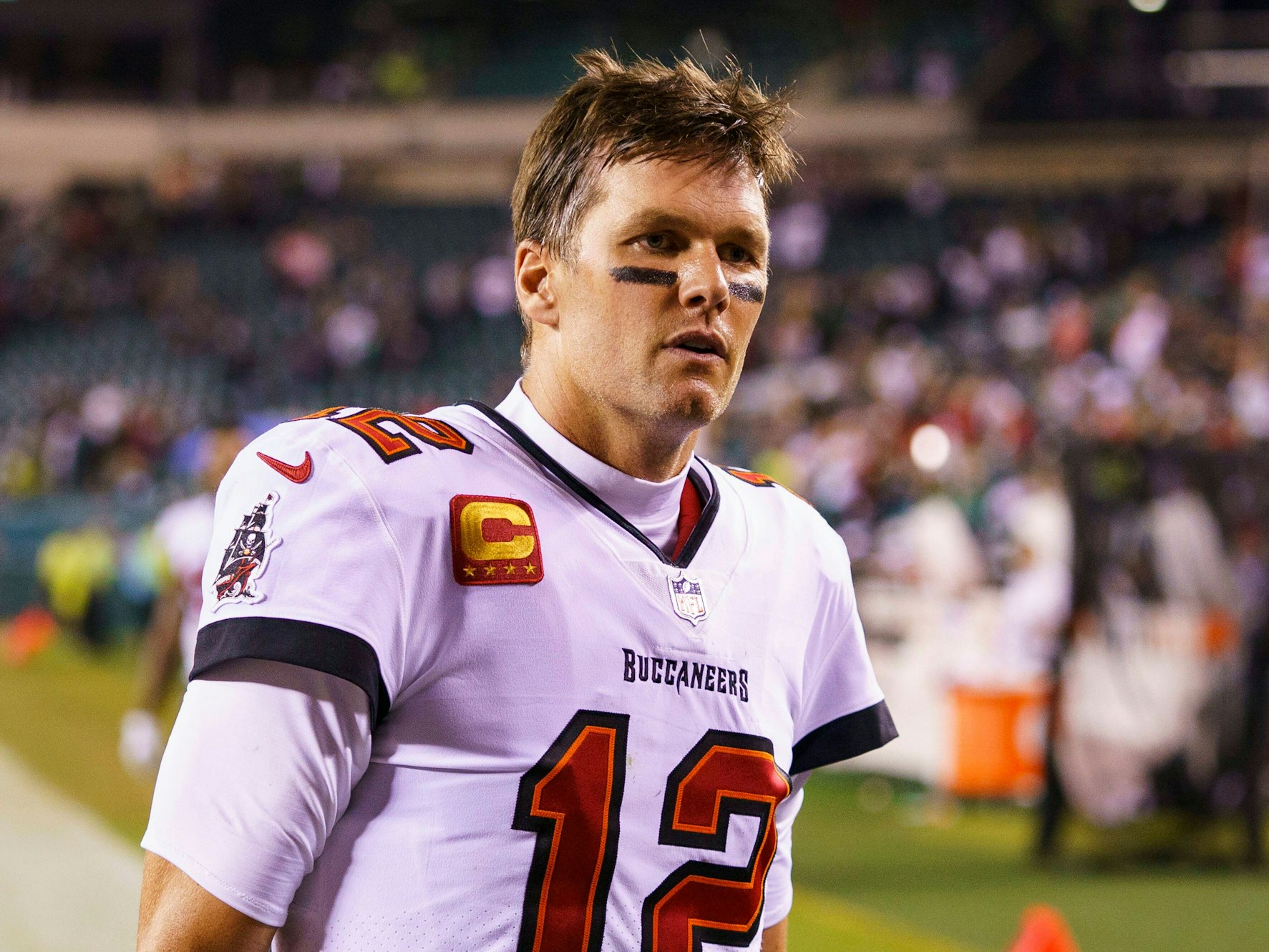 Tom Brady steht im Bucs-Trikot im Stadion von Philadelphia. Unter seinen Augen befinden sich zwei waagerechte schwarze Linien