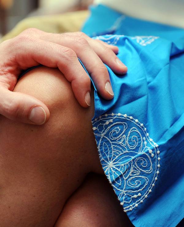Die Hand eines Mannes liegt auf dem Knie einer Frau