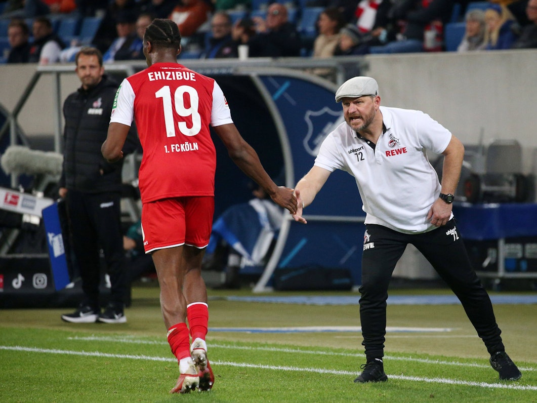 Kingsley Ehizibue klatscht beim Bundesliga-Spiel TSG Hoffenheim gegen 1. FC Köln mit Steffen Baumgart ab.