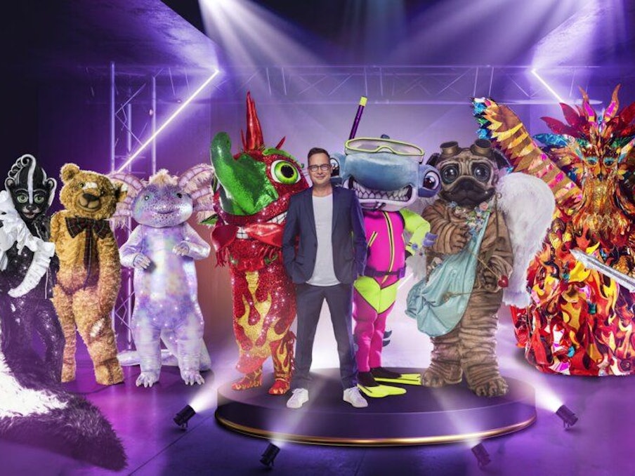 Der Moderator der Show „The Masked Singer“ Matthias Opdenhövel steht mit acht Masken auf der Bühne.