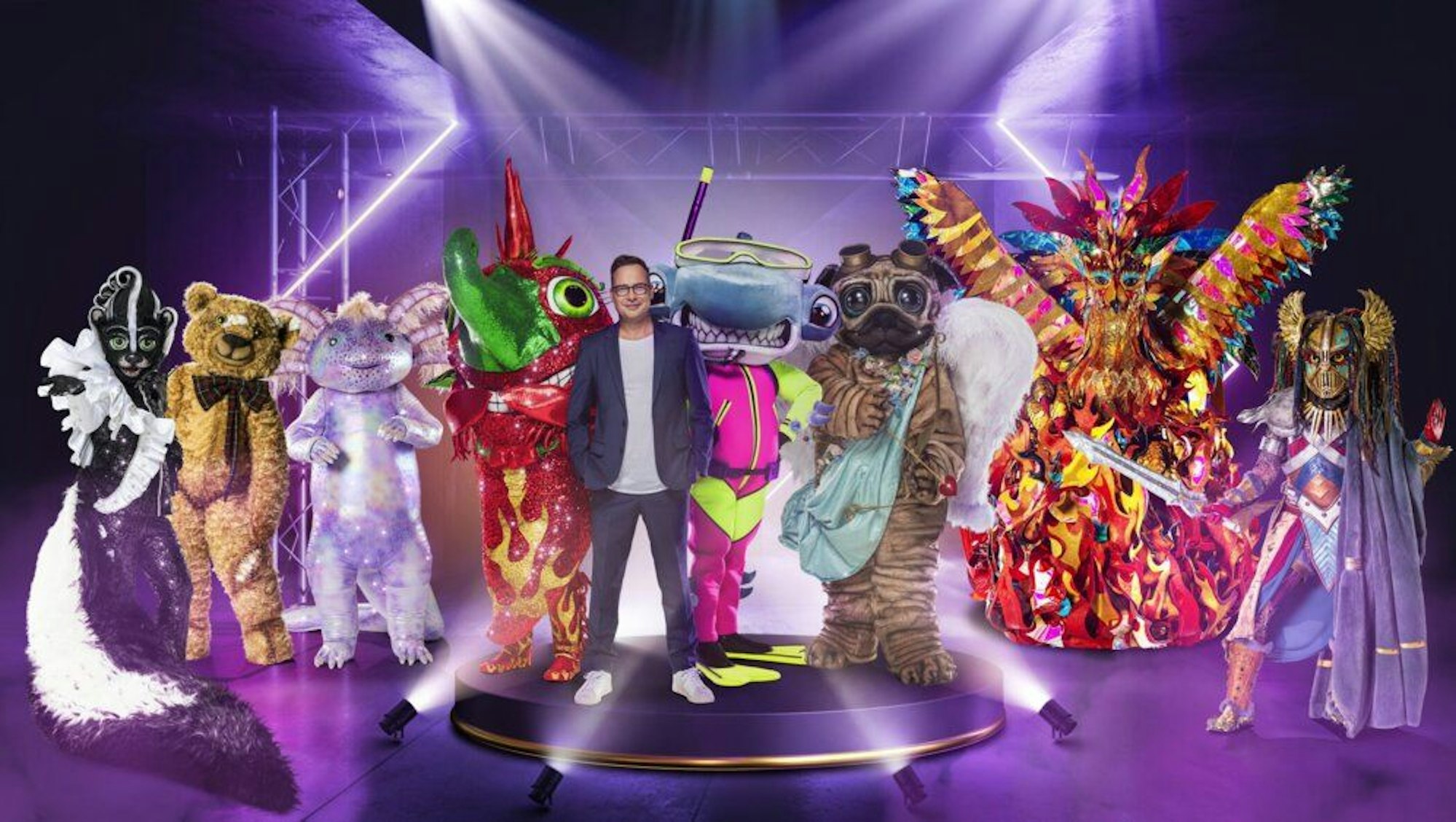 Der Moderator der Show „The Masked Singer“ Matthias Opdenhövel steht mit acht Masken auf der Bühne.
