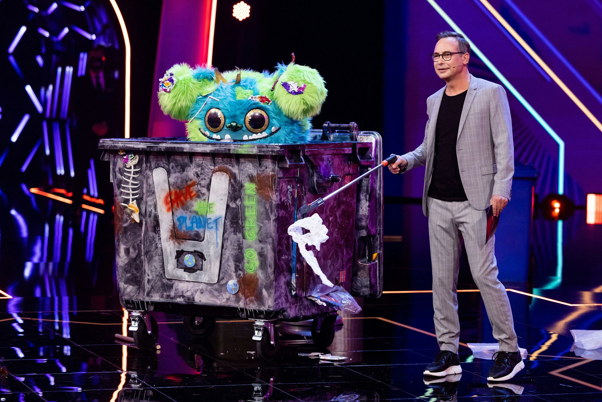 Die Figur „Mülli Müller“ steht in der Prosieben-Show „The Masked Singer “auf der Bühne neben Moderator Matthias Opdenhövel.