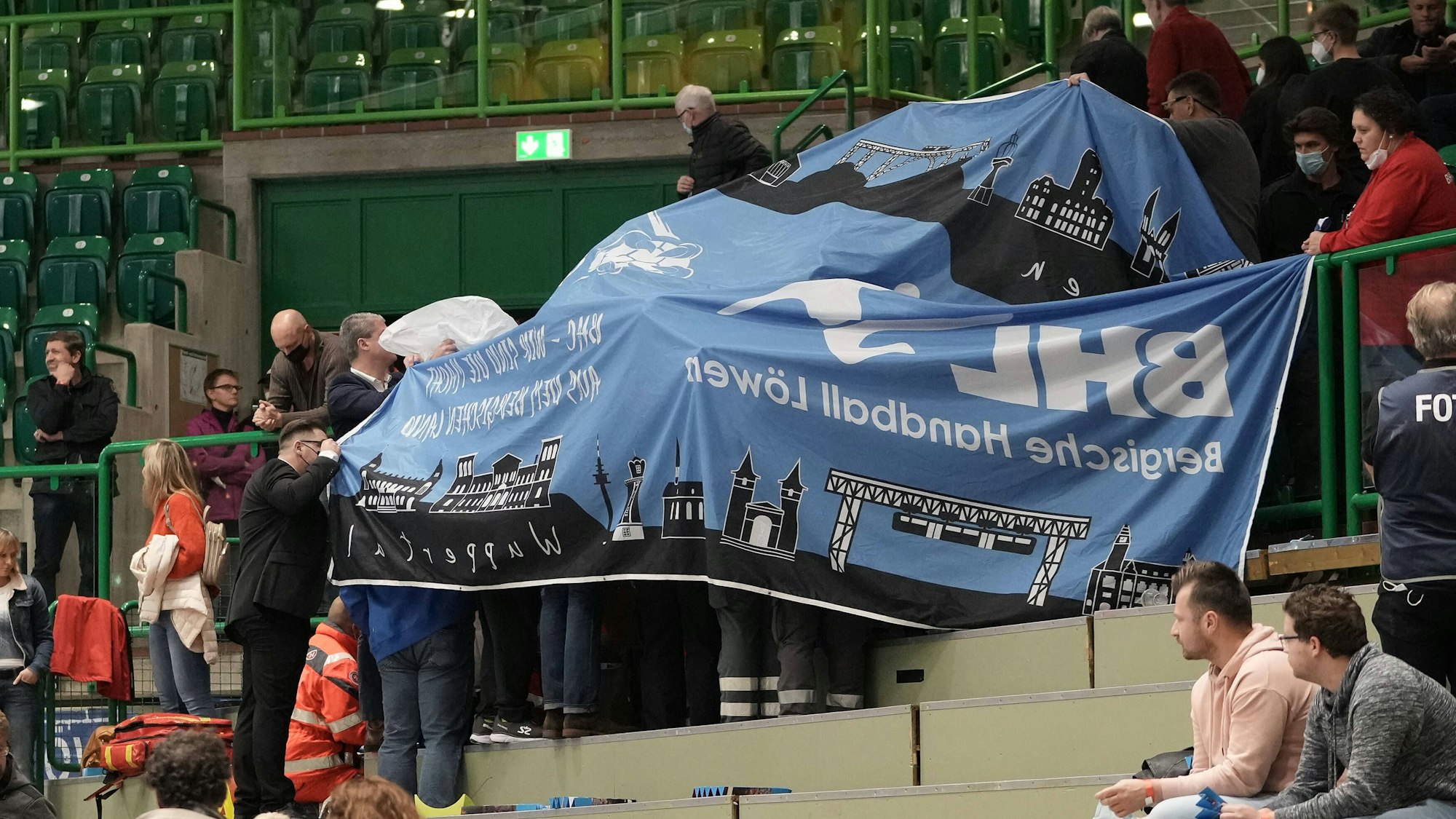 Sanitäter versorgen einen Fan beim Handball-Spiel zwischen dem Bergischen HC und der HSG Wetzlar auf der Tribüne