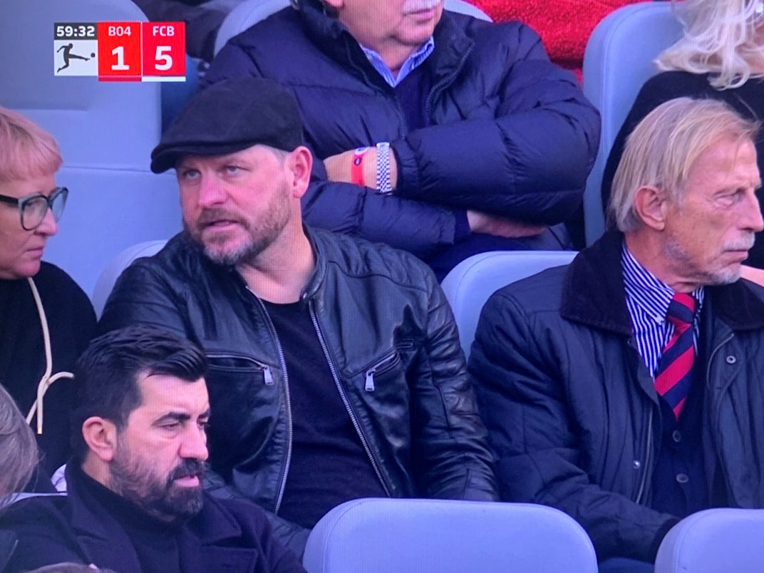 Steffen Baumgart und Christoph Daum gucken das Bundesliga-Spiel Bayer Leverkusen gegen Bayern München.