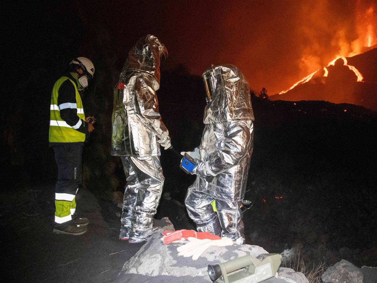 In der Flammenhölle untersuchen Mitarbeiter der Militärischen Nothilfeeinheit in Spezialanzügen die Lava.
