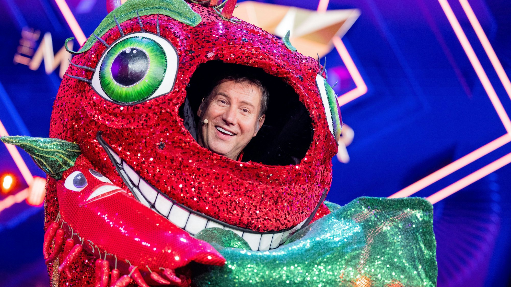 Jens Riewa, Moderator der Tagesschau, steht als enttarnte Figur der Chili in der Prosieben-Show „The Masked Singer“ auf der Bühne.
