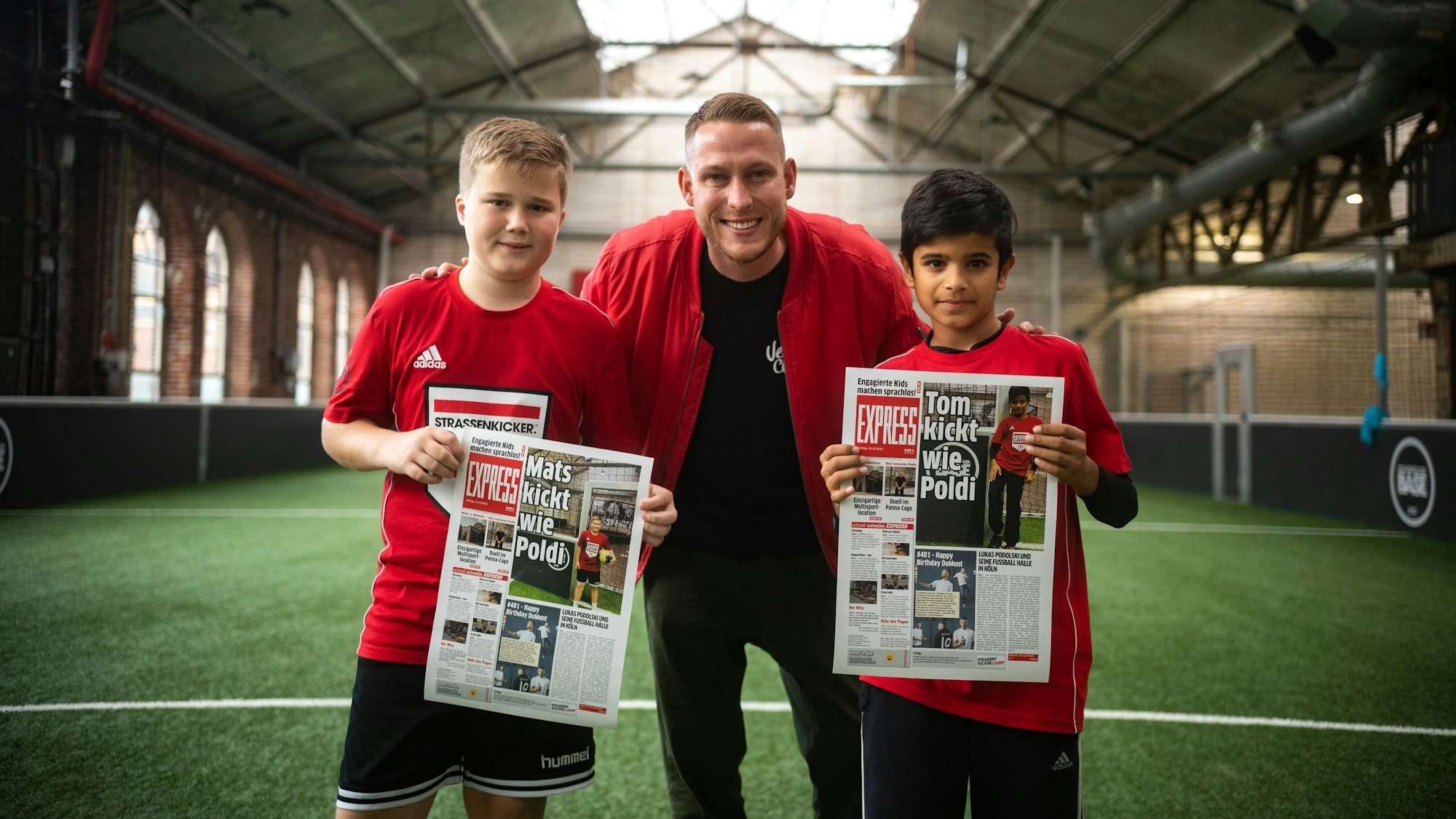 Mats, Tom und Mo-Torres posieren mit ihren EXPRESS-Seiten bei Lukas Podolskis Strassenkicker.Camp.