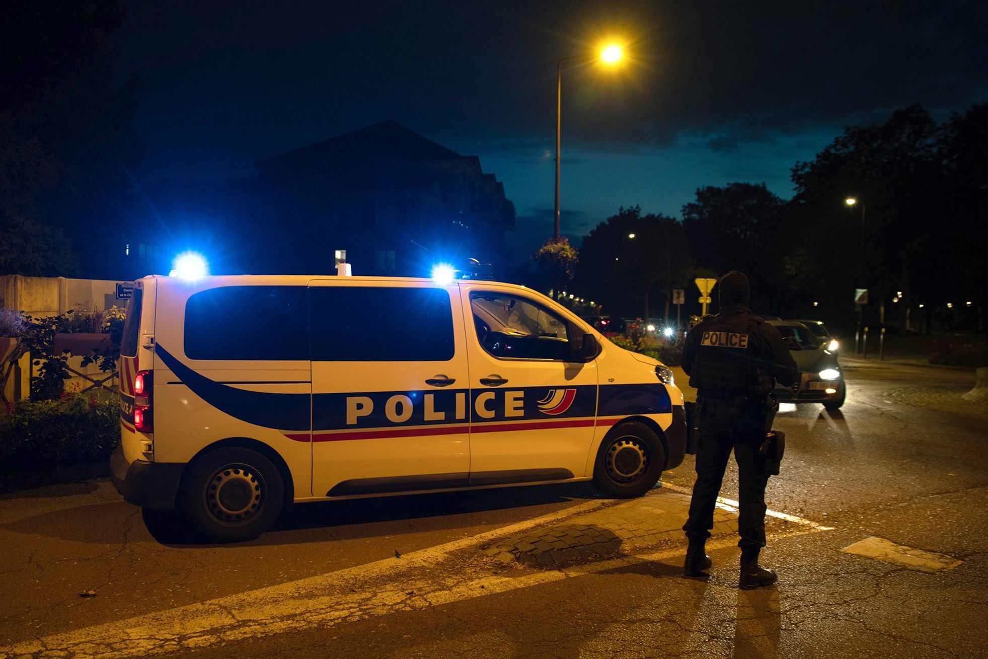 Ein Polizist steht neben einem Einsatzwagen an einem Tatort in der Nähe von Paris, aufgenommen im Oktober 2020.