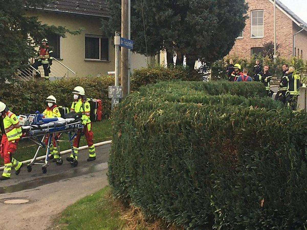 Rettungskräfte schieben eine Trage über die Straße.