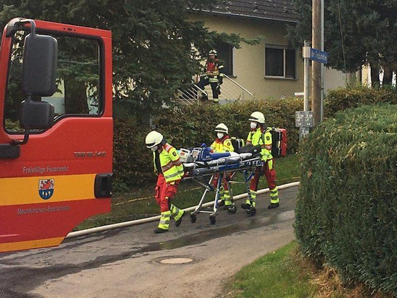 Rettungskräfte schieben eine Trage über die Straße.