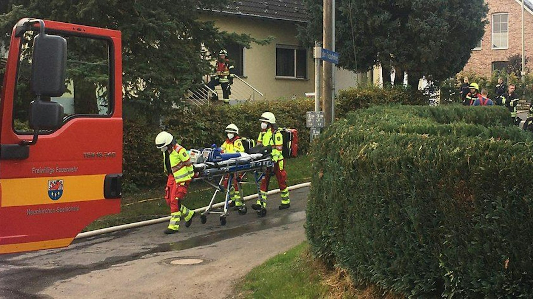 Rettungskräfte schieben eine Trage über die Straße.