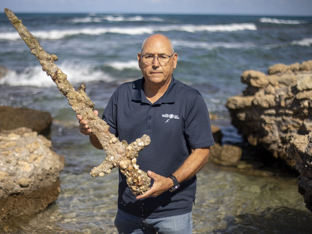 Ein Hobbytaucher findet an der israelischen Mittelmeerküste ein antikes Schwert. Auf dem Foto (aufgenommen am 19. Oktober 2021) sieht man Jacob Sharvit, den Direktor der Abteilung für Meeresarchäologie der israelischen Altertumsbehörde, welcher das Schwert in der Hand hält.