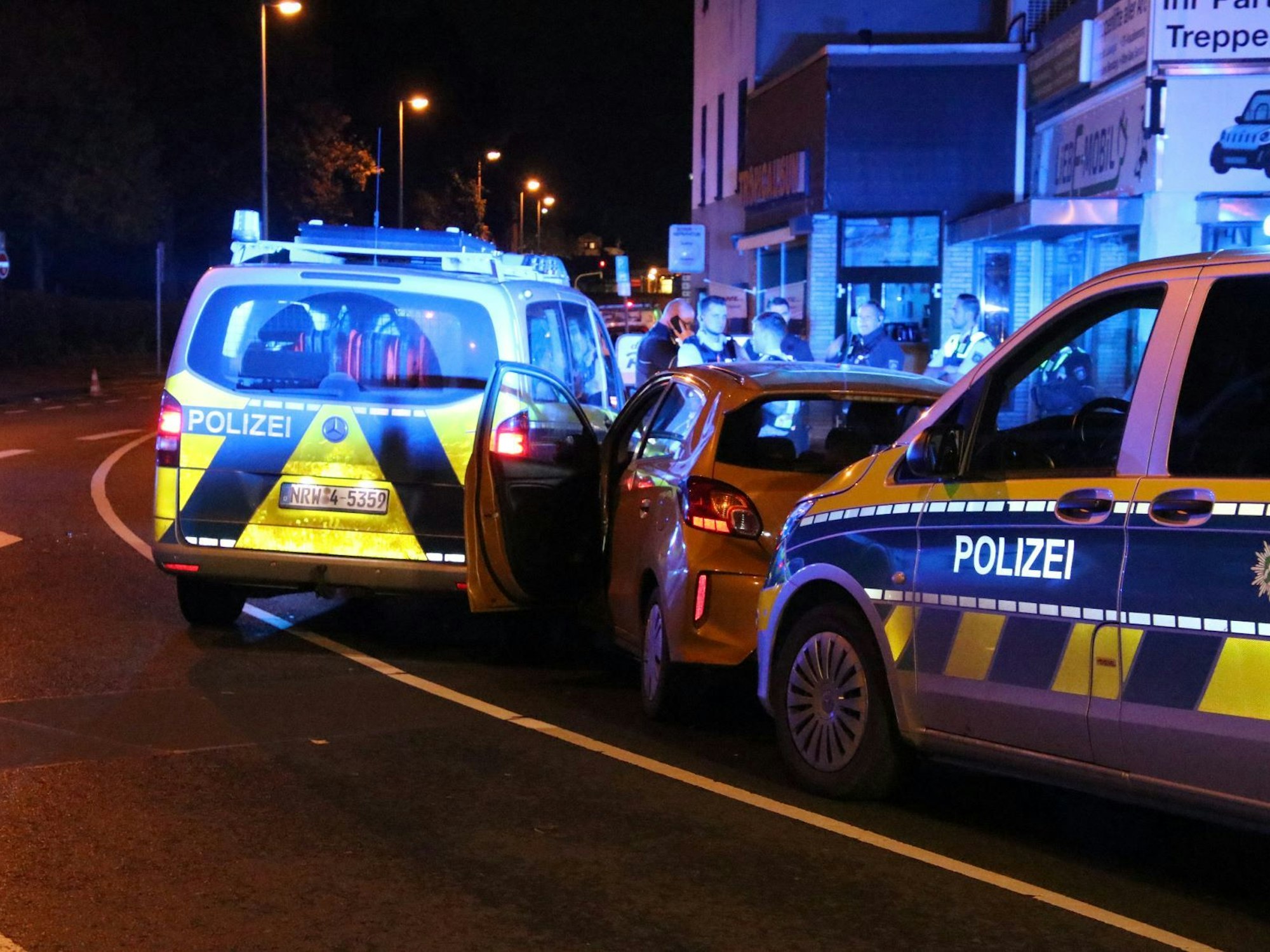 Zwei Polizeifahrzeuge haben einen Kleinwagen eingekesselt.