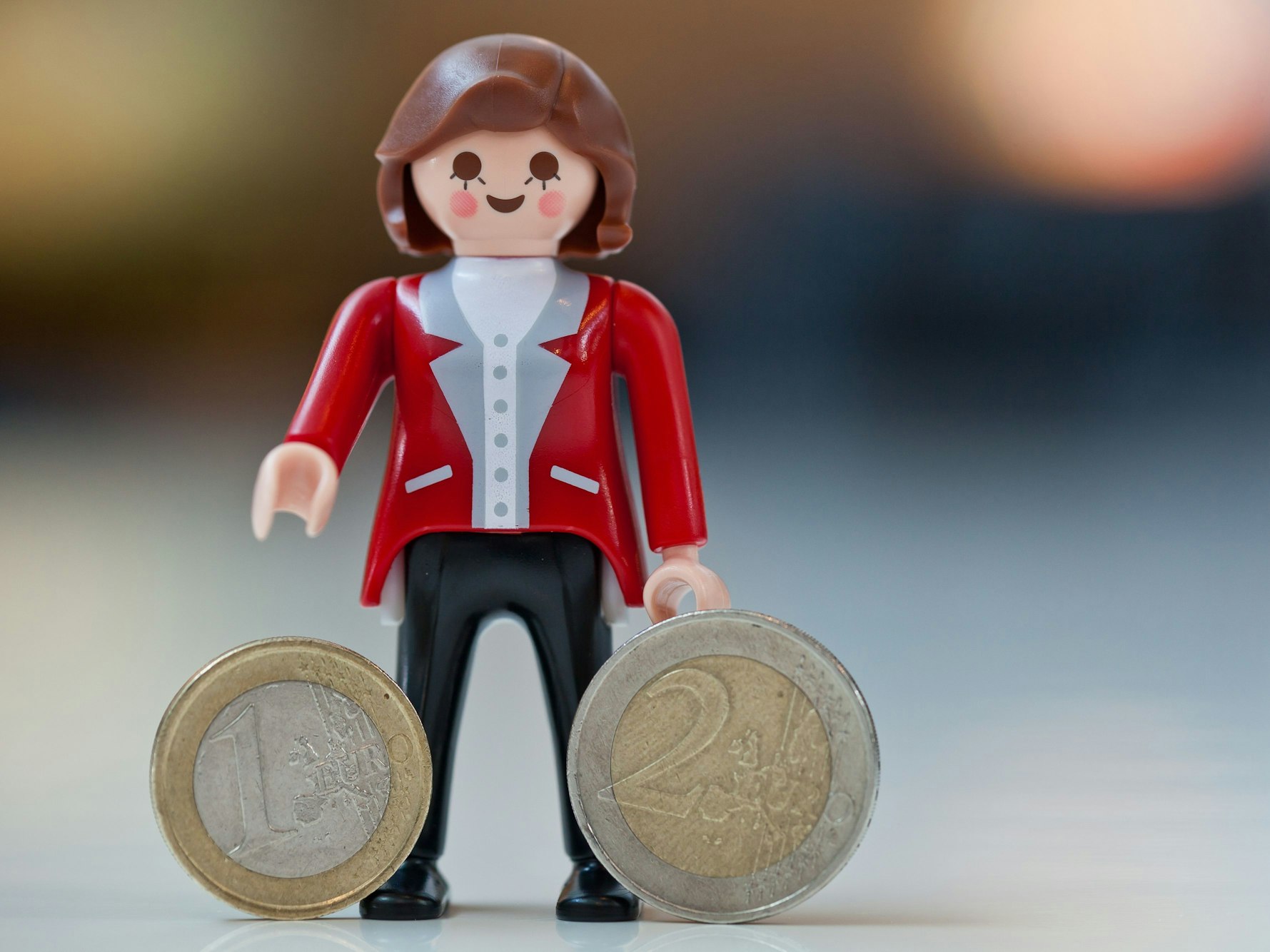 Angela Merkel gibt es auch als Playmobil-Figur. Auf dem Foto (aufgenommen am 28. Juni 2012) sieht man die Playmobil-Figur mit Euro-Münzen auf einem Tisch stehen.