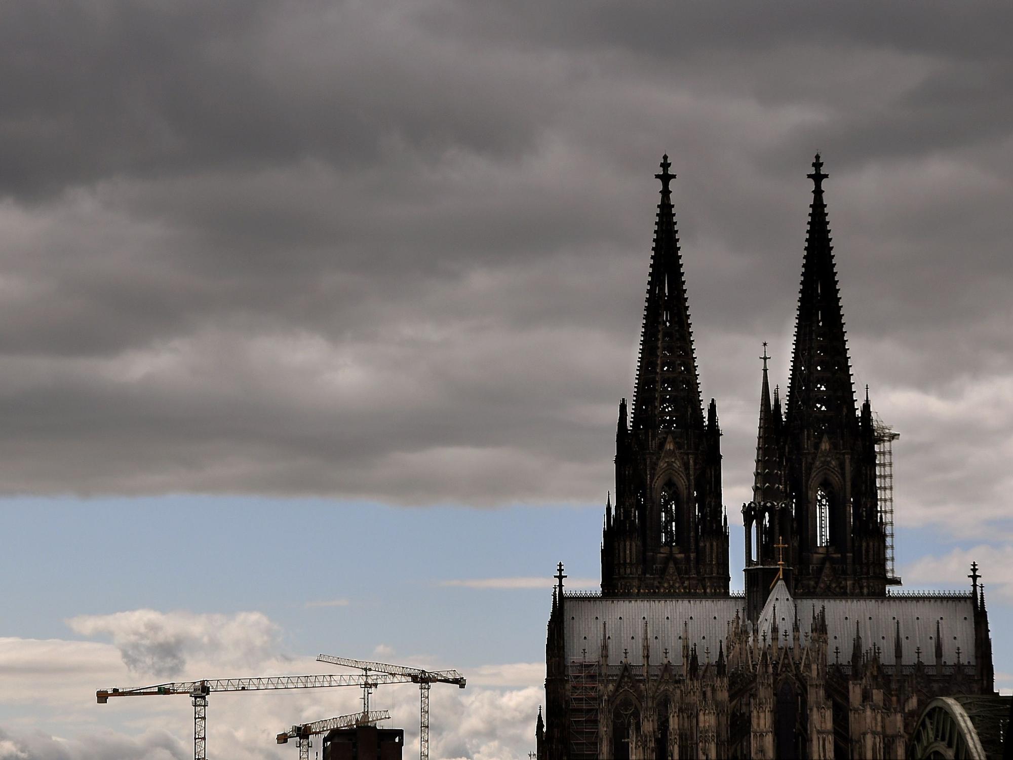 Der Kölner Dom mit seinen Turmspitzen kratzt an den dunklen Wolken.