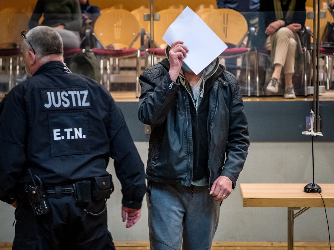 Ein Angeklagter (hier ein Foto vom 18.10.2021) im Mordprozess wird in die Stadthalle geführt. Nach dem Tod einer gefesselten 19-Jährigen in der Weser im niedersächsischen Kreis Nienburg stehen zwei Männer und eine Frau seit Februar wegen Mordes vor Gericht.