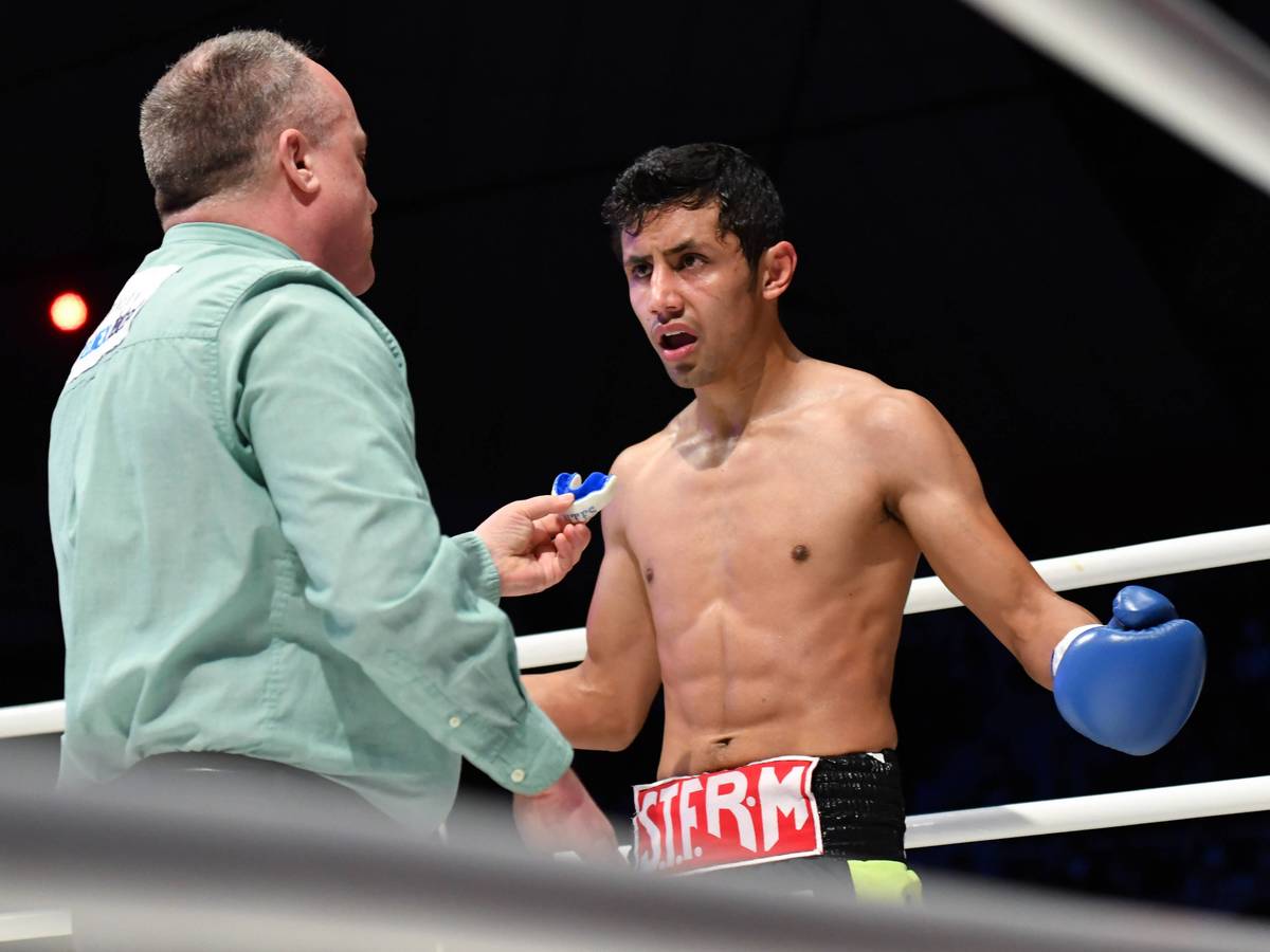 Moisés Fuentes spricht bei einem Boxkampf mit Ringrichter Len Koivisto.