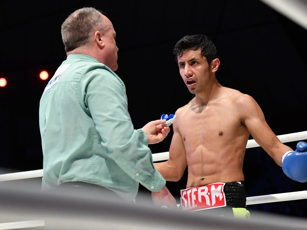 Moisés Fuentes spricht bei einem Boxkampf mit Ringrichter Len Koivisto.