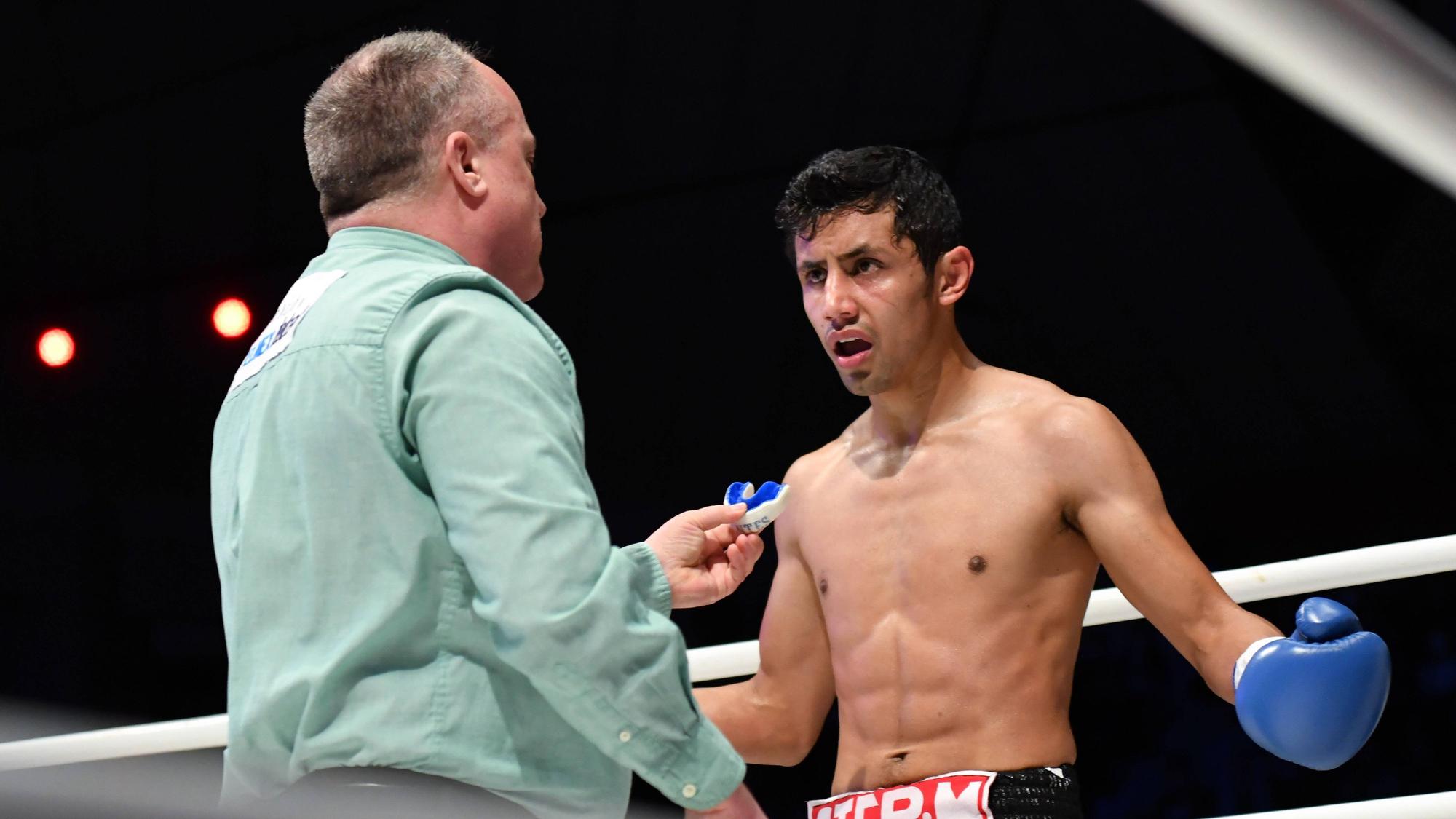 Moisés Fuentes spricht bei einem Boxkampf mit Ringrichter Len Koivisto.