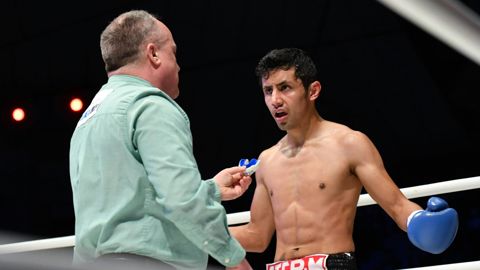 Moisés Fuentes spricht bei einem Boxkampf mit Ringrichter Len Koivisto.