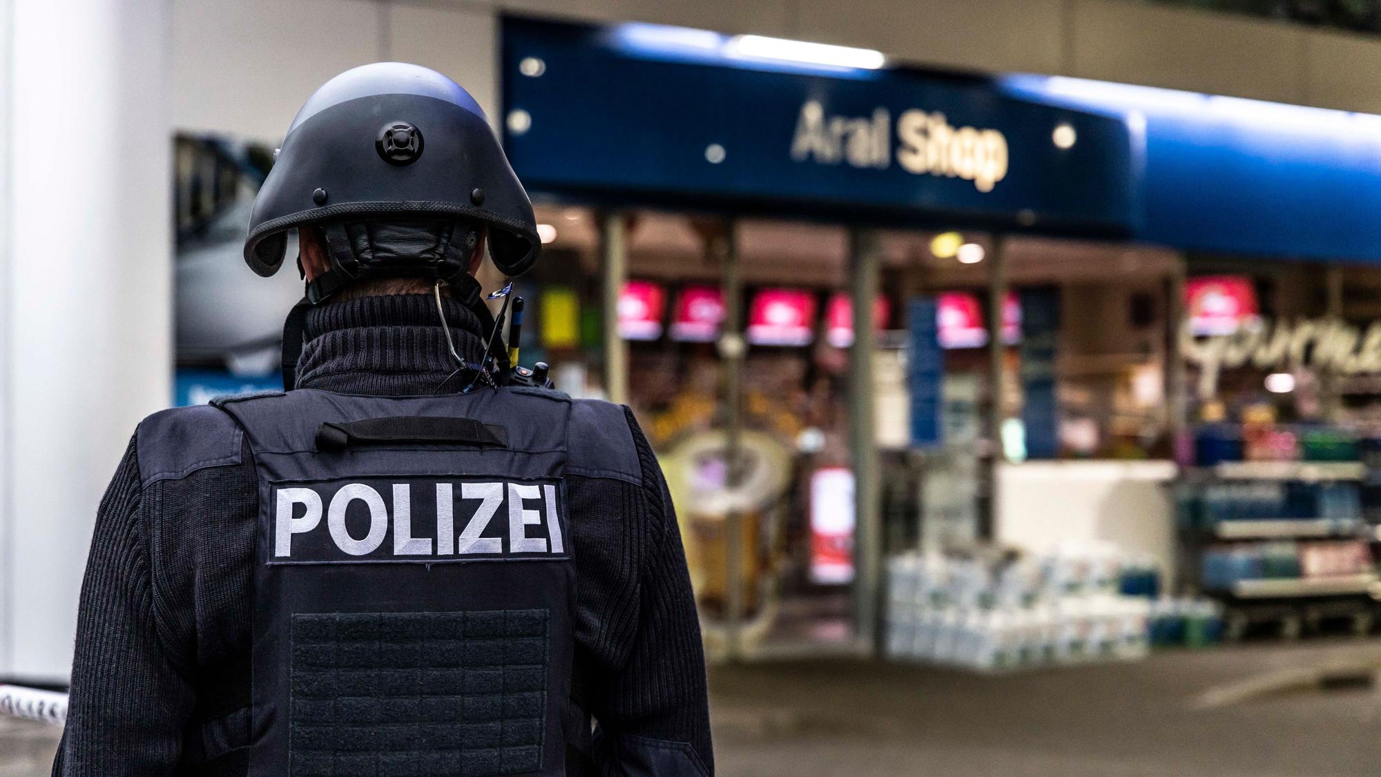 Ein Polizist sichert im September 2021 eine Tankstelle in Idar-Oberstein, nachdem ein Mitarbeiter von einem Maskenverweigerer erschossen wurde.