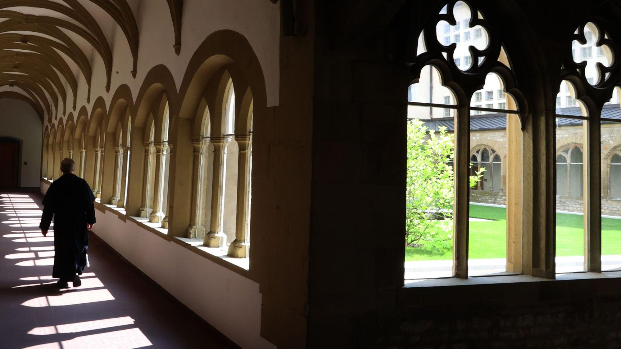 Ein Mönch läuft durch den Kreuzgang eines Franziskanerklosters in Würzburg. In Speyer hat ein Mann eine Nonne beschuldigt, ihn als Kind jahrelang missbraucht zu haben.