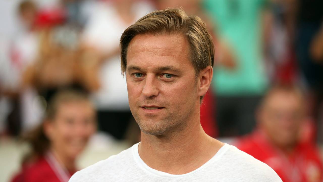 Timo Hildebrand steht vor einem Spiel des VfB Stuttgart in Zivil auf dem Rasen.