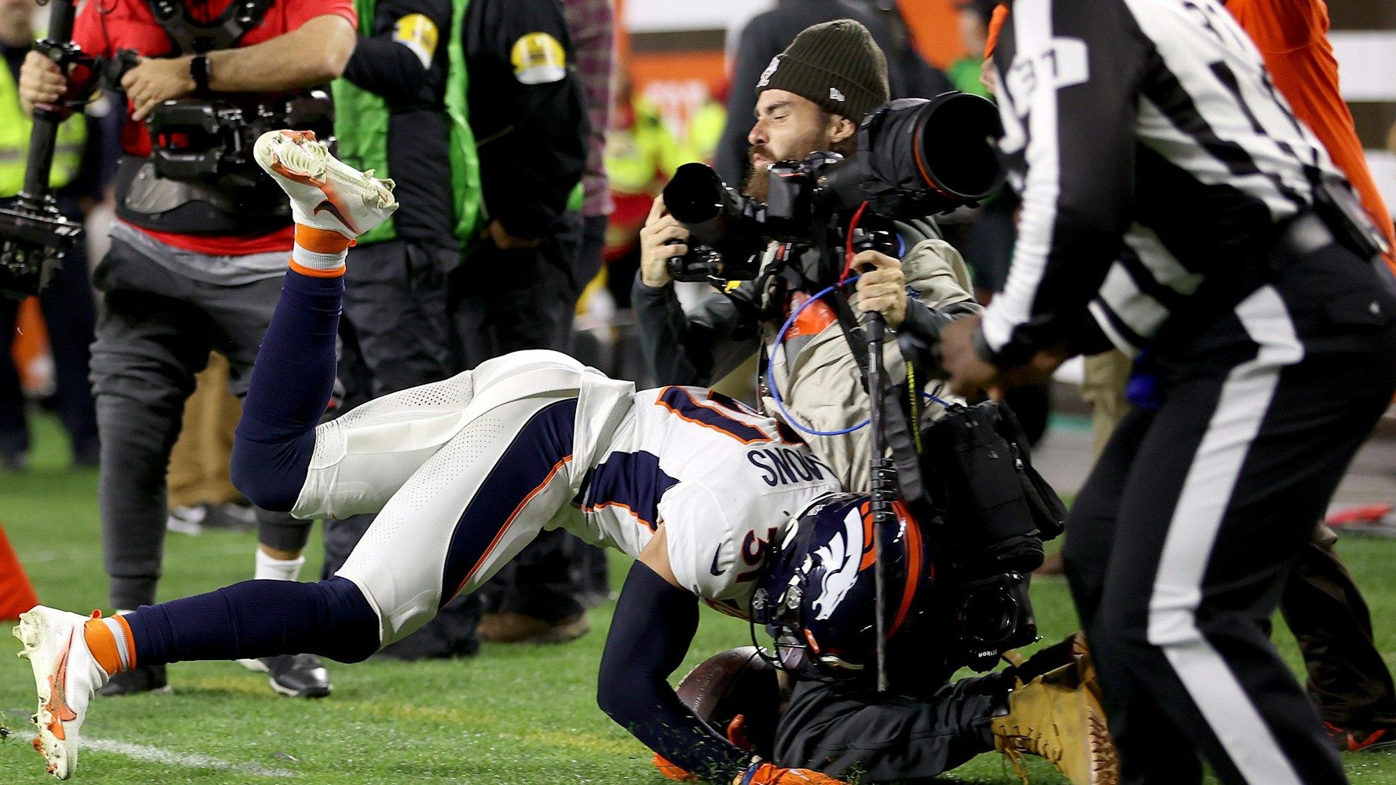 Justin Simmons von den Denver Broncos räumt im NFL-Spiel gegen die Cleveland Browns Fotograf Matt Starkey ab.