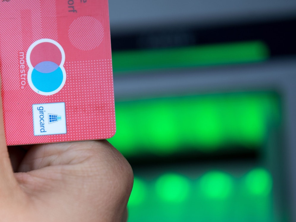 Eine Bankkundin hebt mit ihrer Girokarte Bargeld von einem Geldautomaten ab. Ab 1. Juli 2023 dürfen nach einer Entscheidung des US-Kartenriesen Mastercard keine Maestro-fähigen Girokarten mehr ausgegeben werden, die den Einsatz der beliebten Zahlungskarte außerhalb Deutschlands ermöglichen.