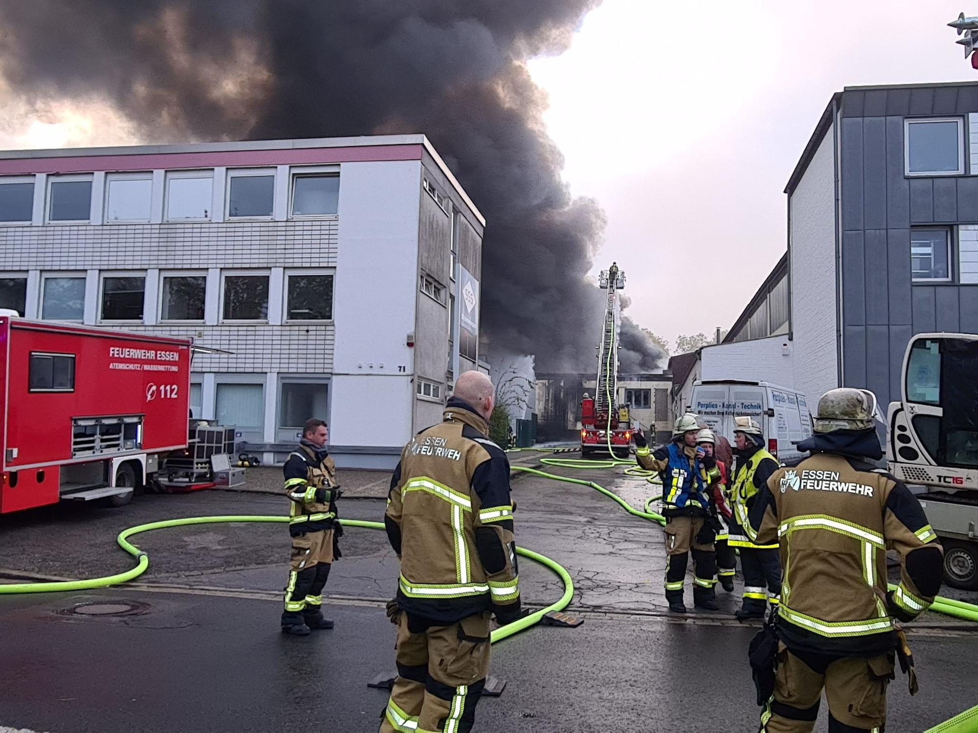 Feuerwehrleute löschen den Brand in der Lagerhalle einer Textildruckfirma.