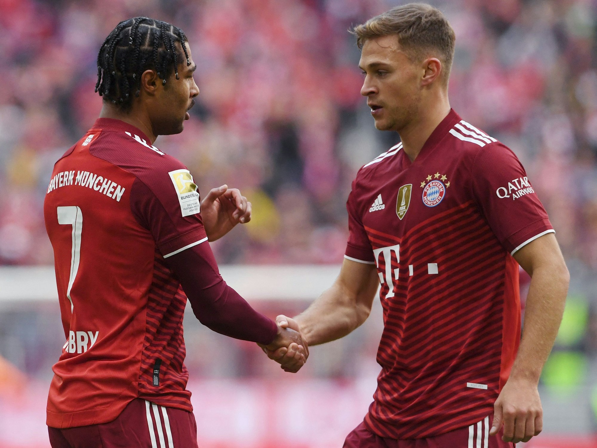 Bayern Münchens Serge Gnabry und Joshua Kimmich geben sich die Hand.