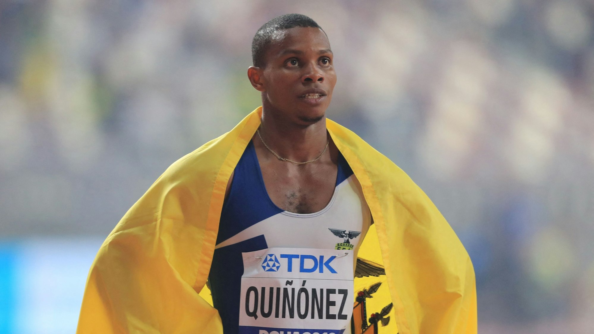 Sprinter Álex Quiñónez hat die Flagge Ecuadors um seine Schultern.
