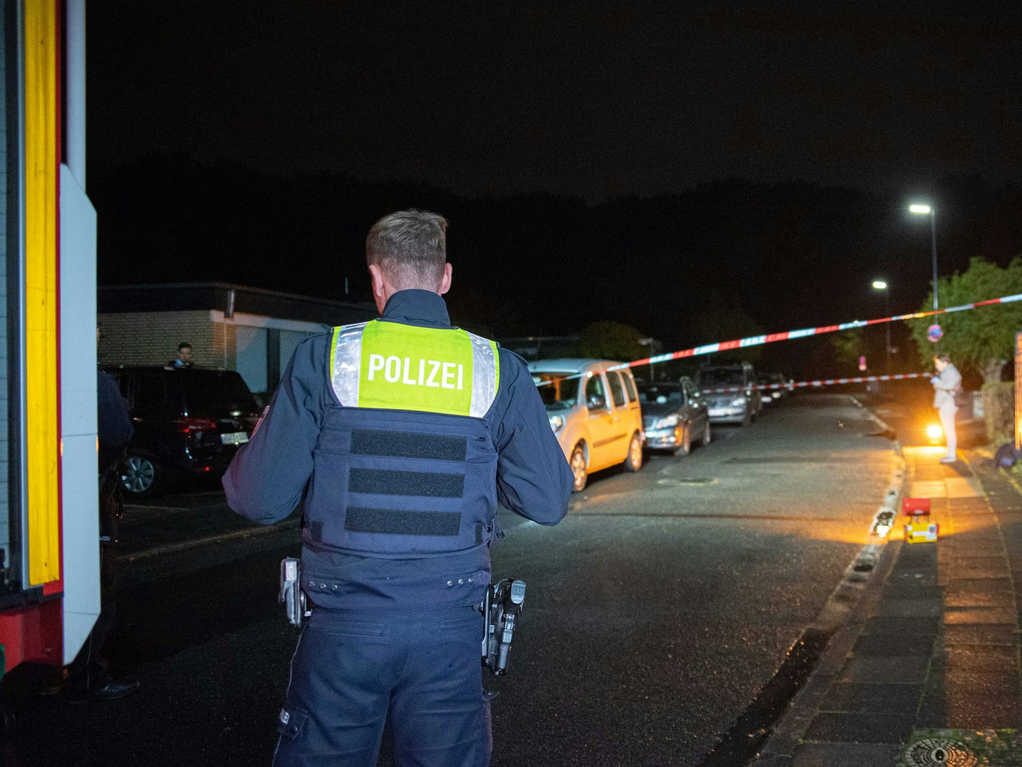 Die Polizei steht am späten Abend in Hürth im Rhein-Erft-Kreis am Tatort, an dem ein bewaffneter Mann in das Haus einer Familie eingedrungen war.