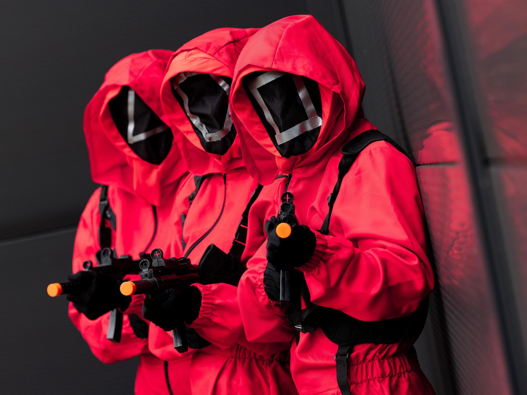 Mitarbeiter des Kostümhändlers Deiters posieren in Kostümen aus der Serie „Squid Game“ des Streaming-Anbieters Netflix.