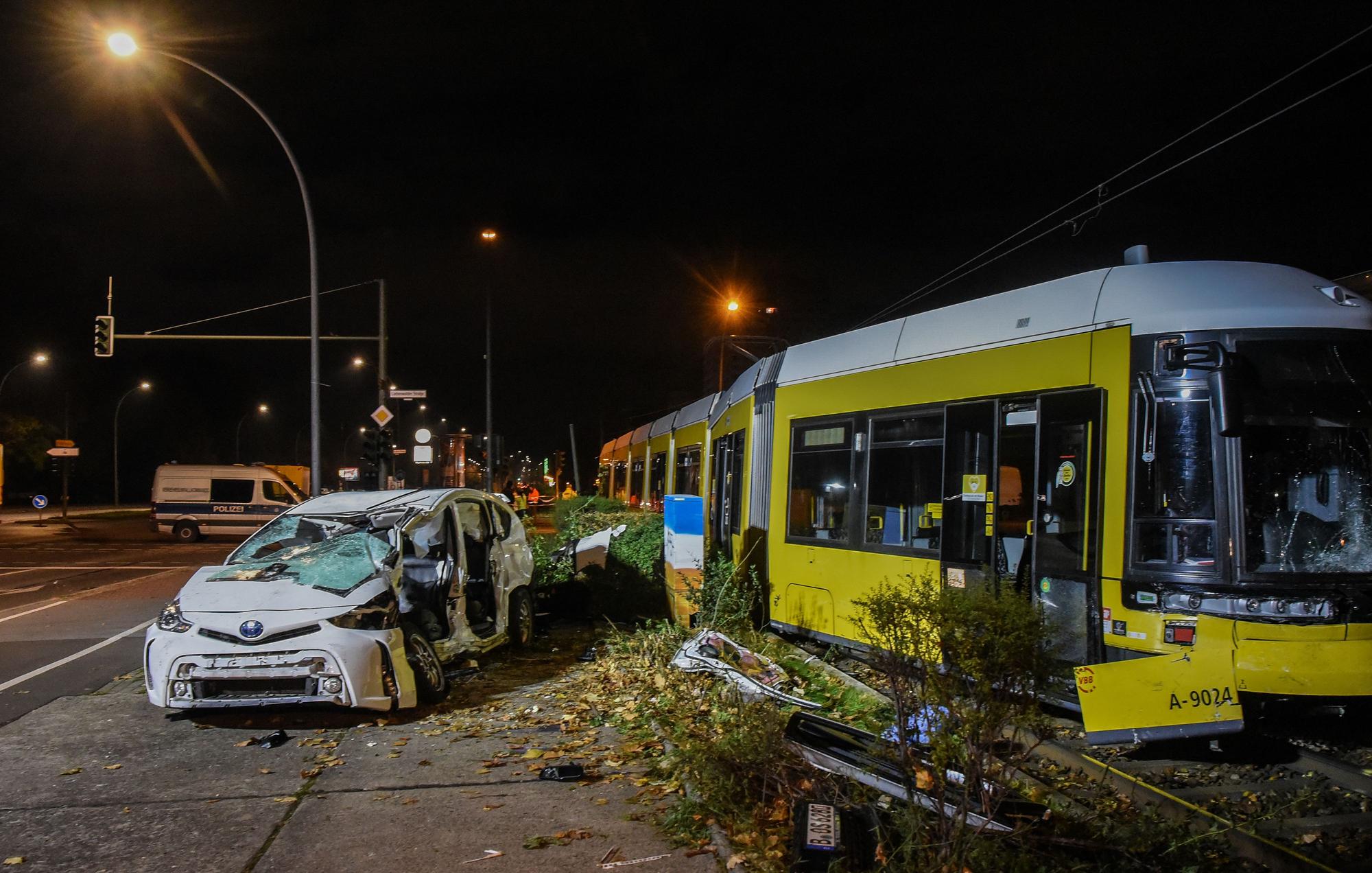 Ein zerstörter Pkw steht am frühen Sonntagmorgen neben einer beschädigten Straßenbahn.