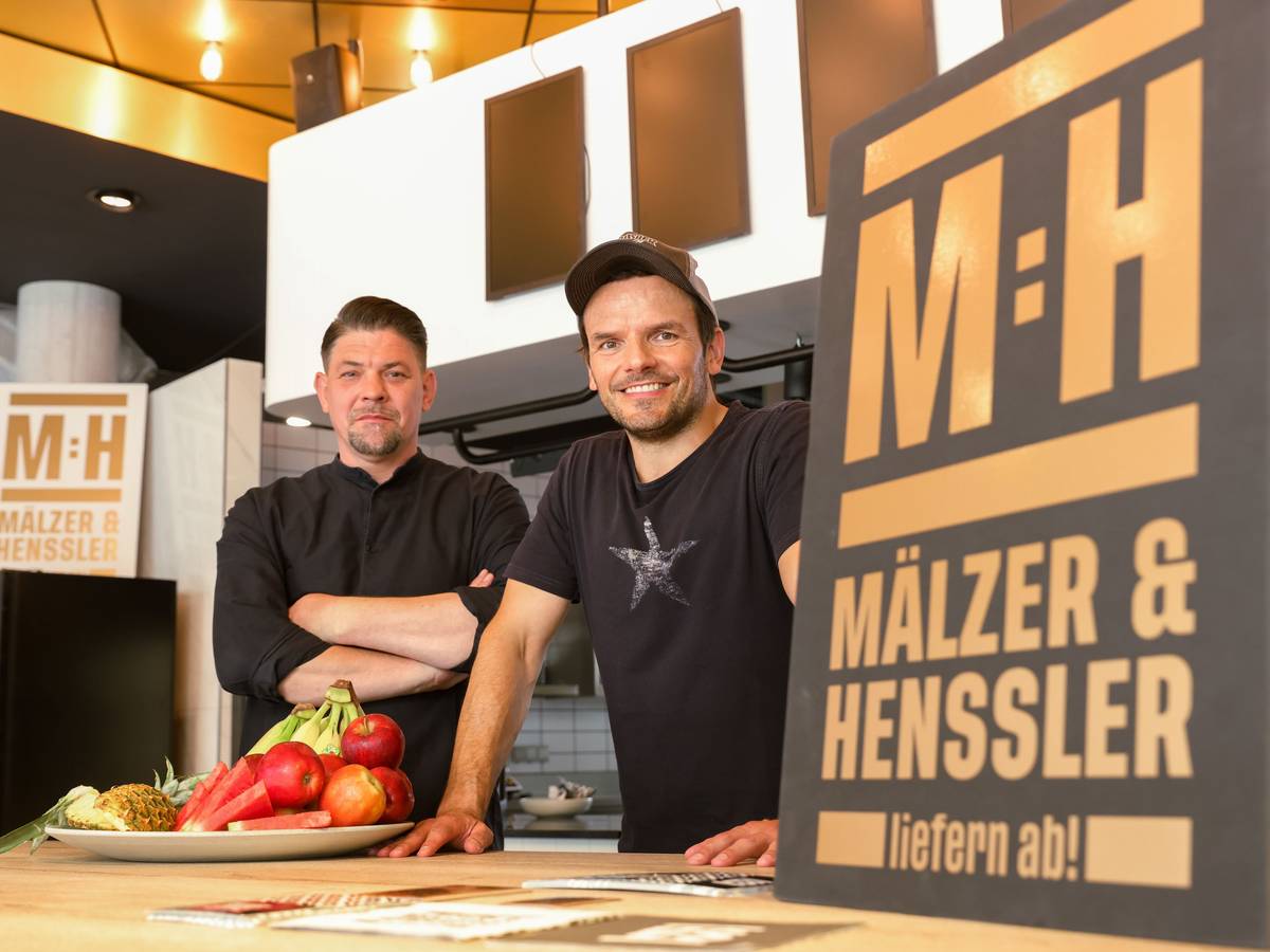Tim Mälzer und Steffen Henssler stehen im Studio der neuen Kochshow „Mälzer und Henssler liefern ab!“ bei Vox