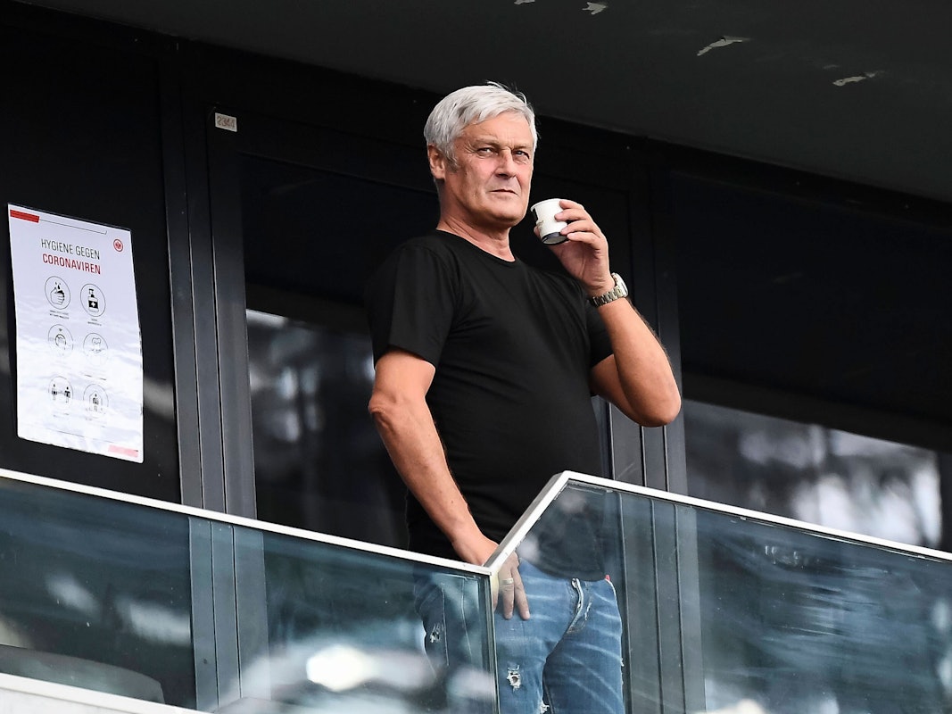 Armin Veh steht mit einer Tasse auf der Tribüne.