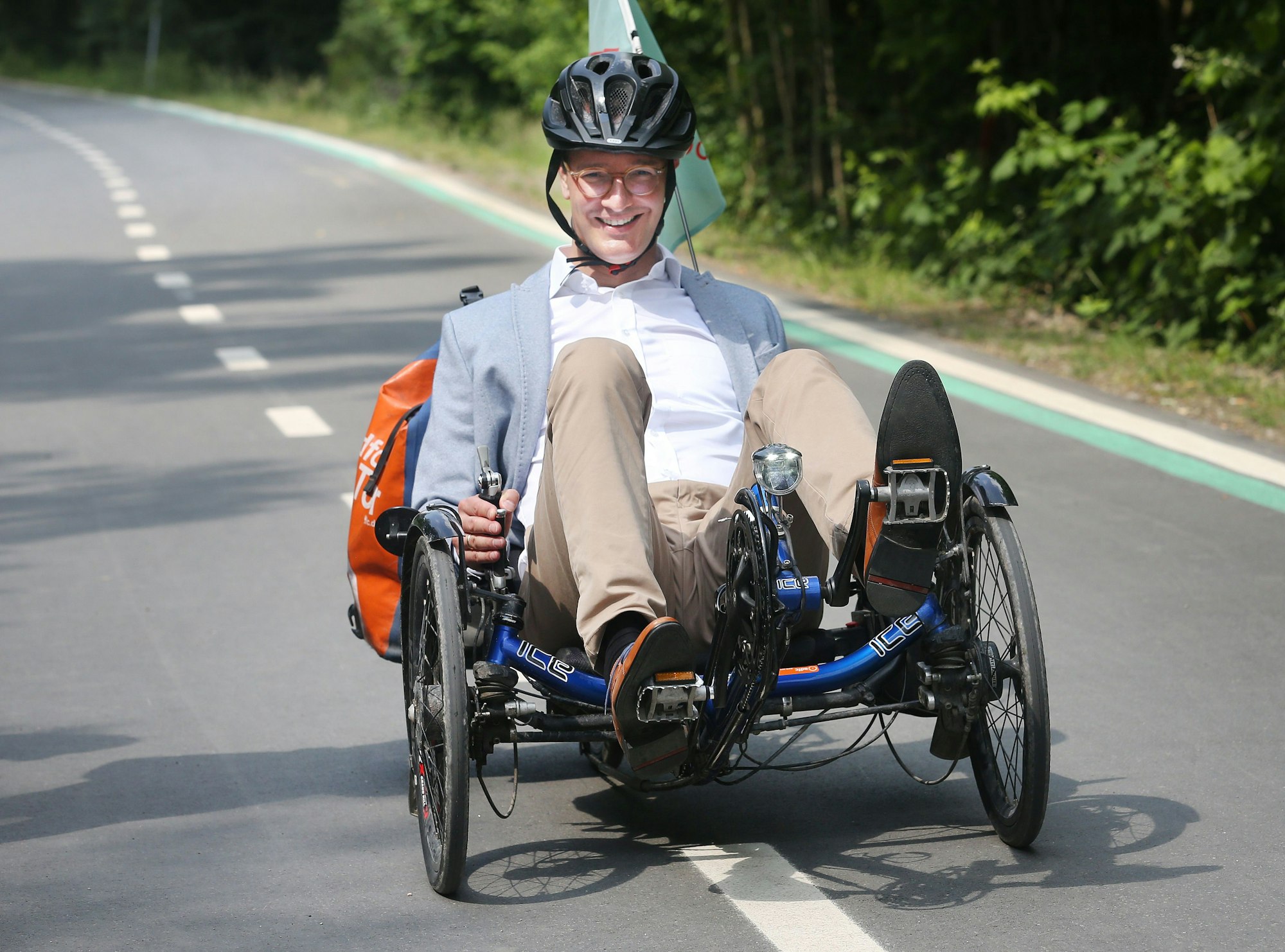 Hendrik Wüst fährt mit einem Liegerad über den Radweg.