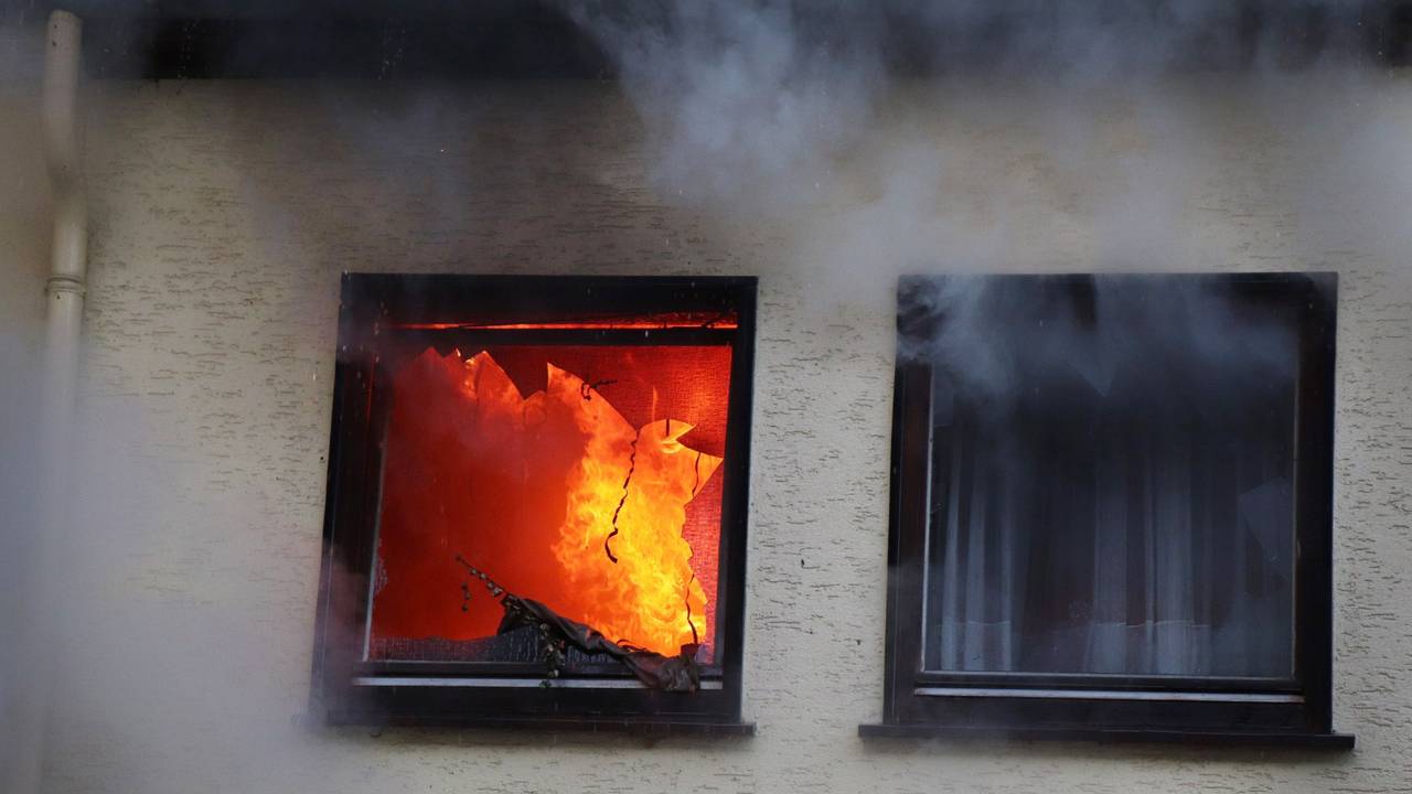 Hinter einem Fenster eines Hauses in Dortmund sind am 9. Januar 2019 Flammen zu sehen.