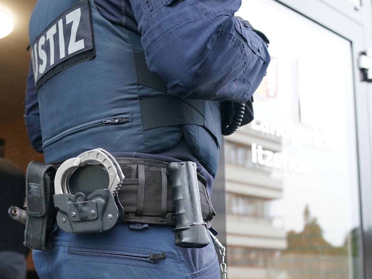 In Bayern wurde ein 14-jähriges Mädchen im Schlaf ermordet. Der Verdächtigte wurde festgenommen. Unser Symbolbild (aufgenommen am 19. Oktober 2021) zeigt einen Justizbeamten, der vor einem Eingang steht. Man sieht nur einen Teil von seinem Rücken.