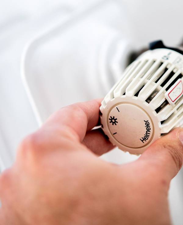 Das Heizen im Winter ist für viele nicht gerade billig. Doch es gibt einige Tipps, um Strom und Geld beim Heizen zu sparen. Auf dem Symbolfoto (aufgenommen am 4. Oktober 2021) sieht man einen Mann, der in einer Wohnung am Thermostat einer Heizung dreht.