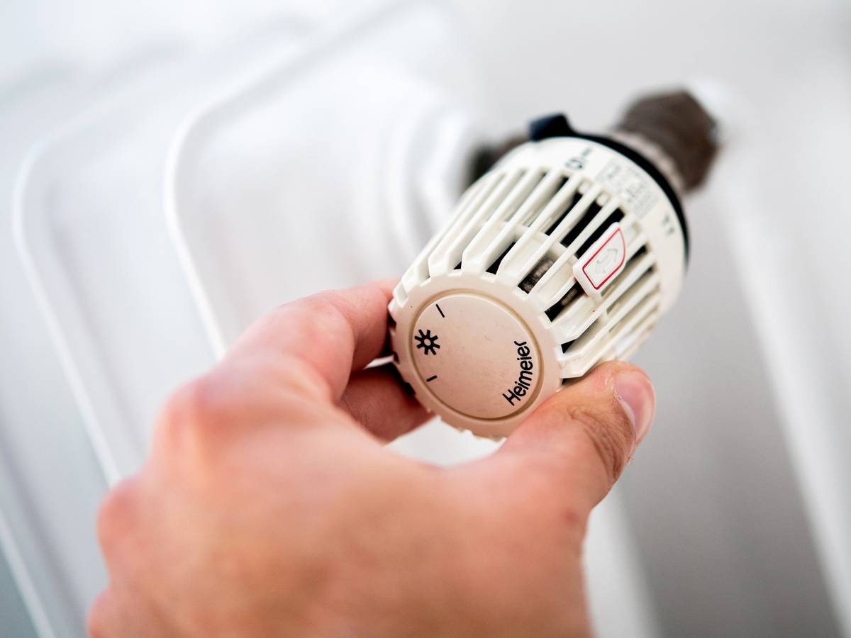 Das Heizen im Winter ist für viele nicht gerade billig. Doch es gibt einige Tipps, um Strom und Geld beim Heizen zu sparen. Auf dem Symbolfoto (aufgenommen am 4. Oktober 2021) sieht man einen Mann, der in einer Wohnung am Thermostat einer Heizung dreht.