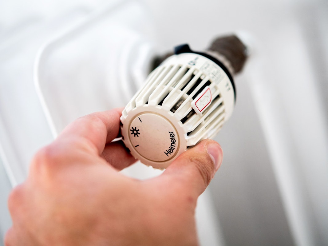 Das Heizen im Winter ist für viele nicht gerade billig. Doch es gibt einige Tipps, um Strom und Geld beim Heizen zu sparen. Auf dem Symbolfoto (aufgenommen am 4. Oktober 2021) sieht man einen Mann, der in einer Wohnung am Thermostat einer Heizung dreht.