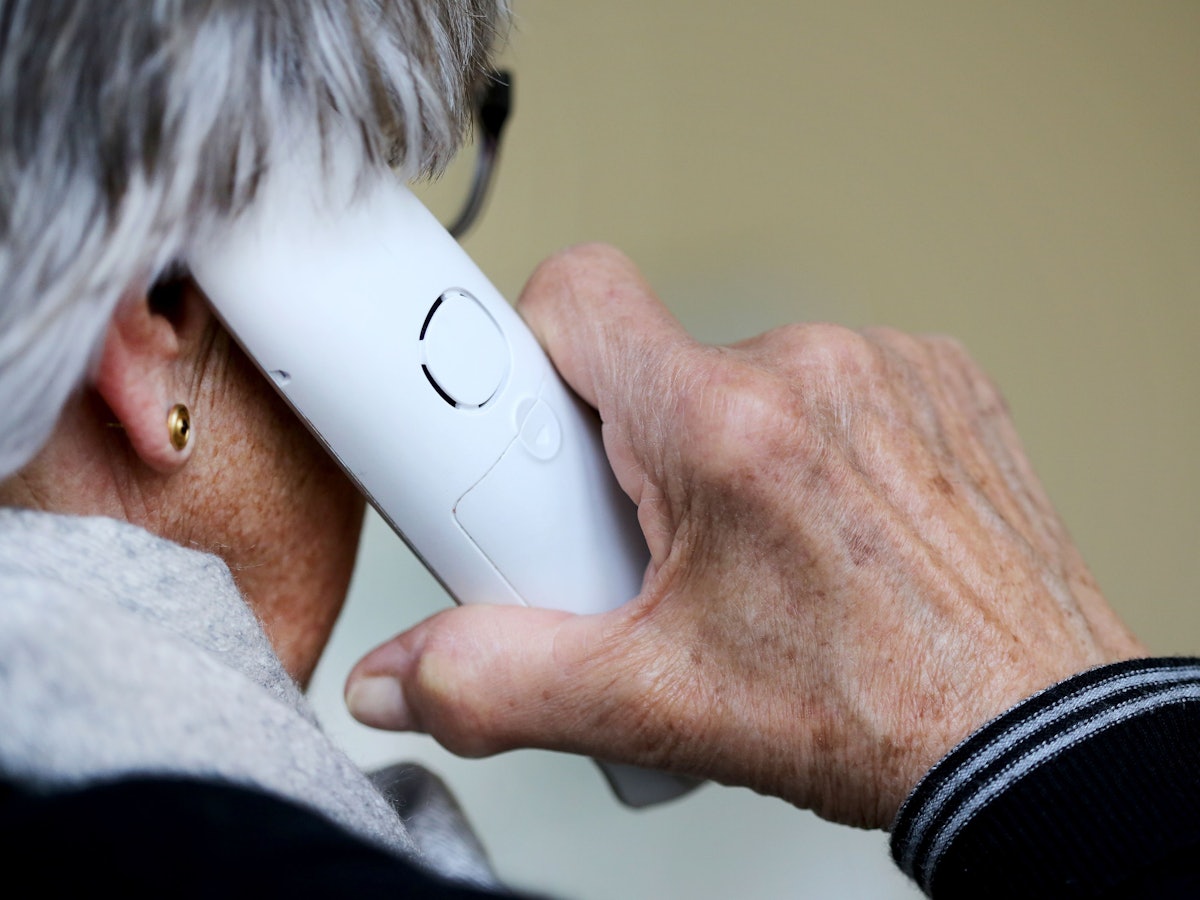 Das Symbolfoto (aufgenommen am 10. März 2021) zeigt eine ältere Dame, die in ihrer Wohnung ein Telefongespräch annimmt.
